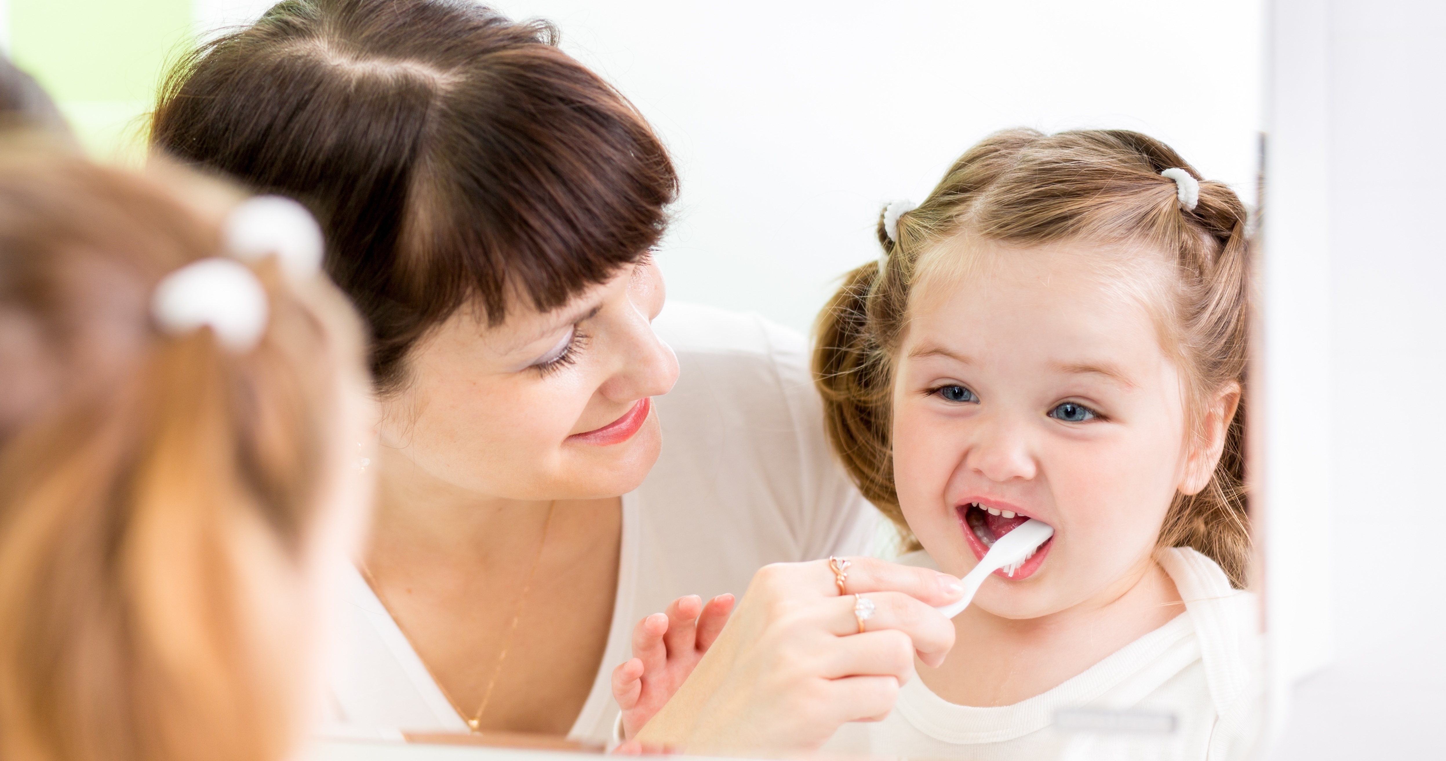 toddler oral health - Mom brushing child's teeth