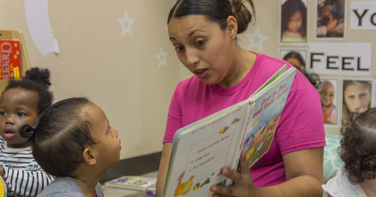 Early childhood educator reading to student
