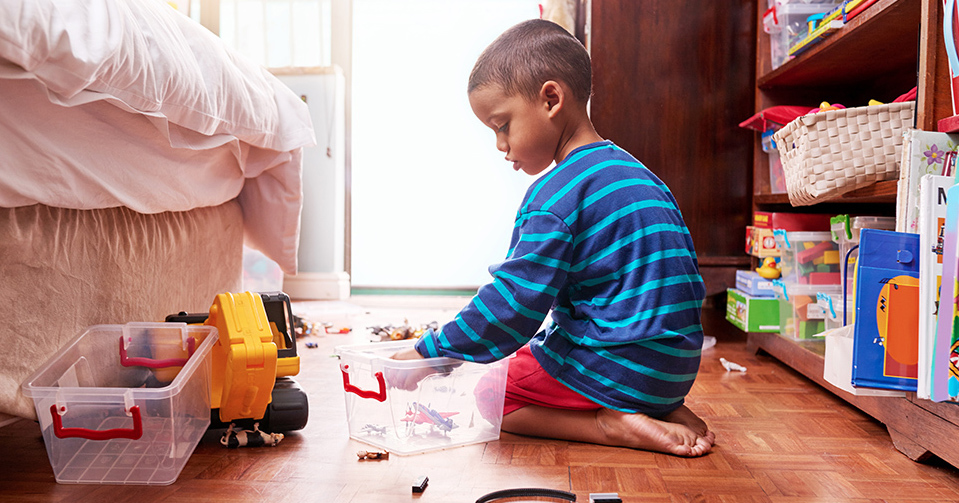 boy picking up toys