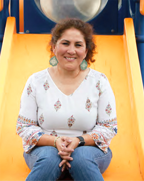 Doralina Martinez sitting on playground slide