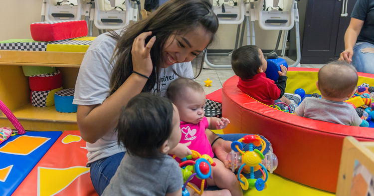 infant caregiver interacts with babies