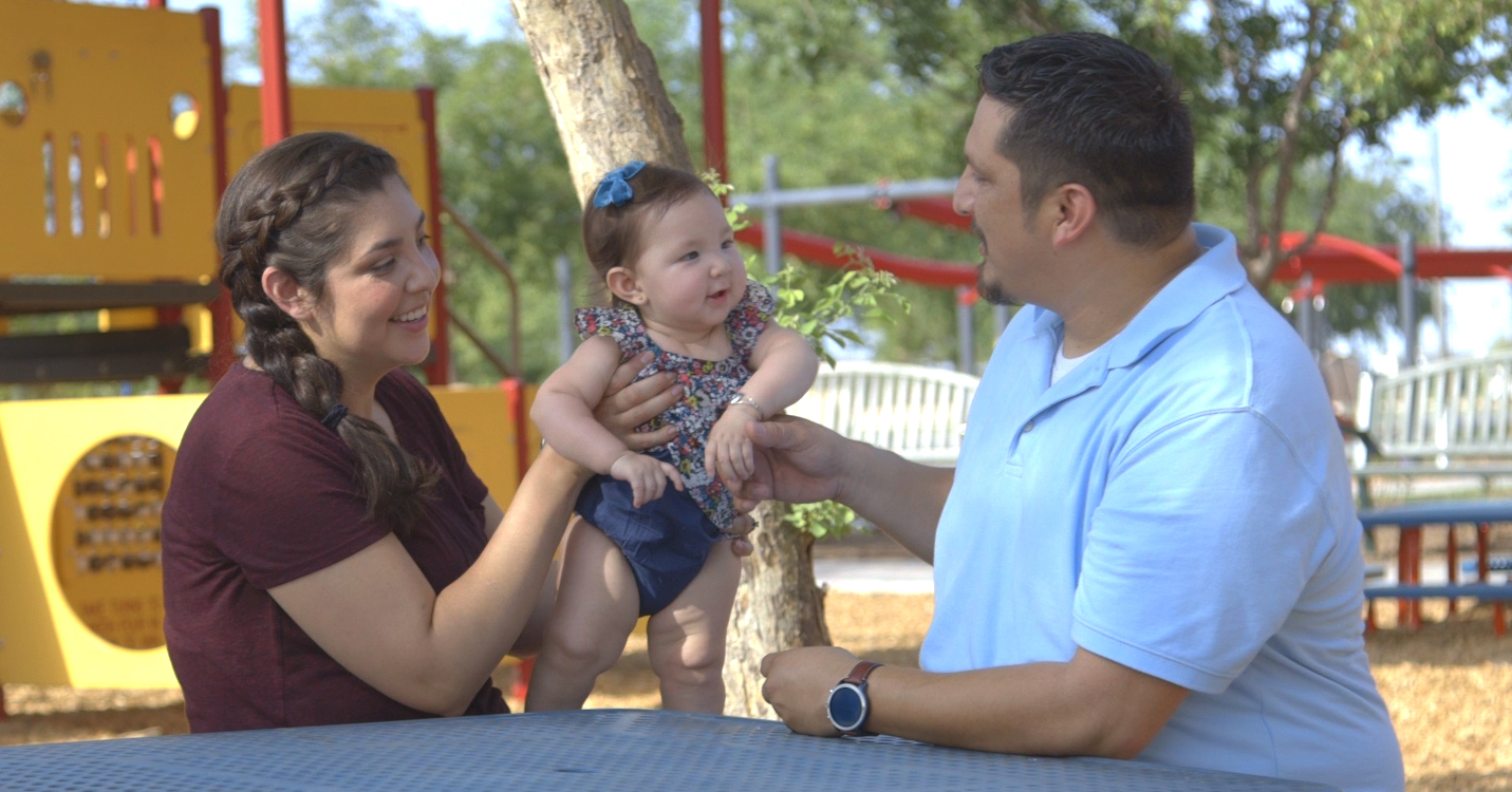 parents with baby in a park