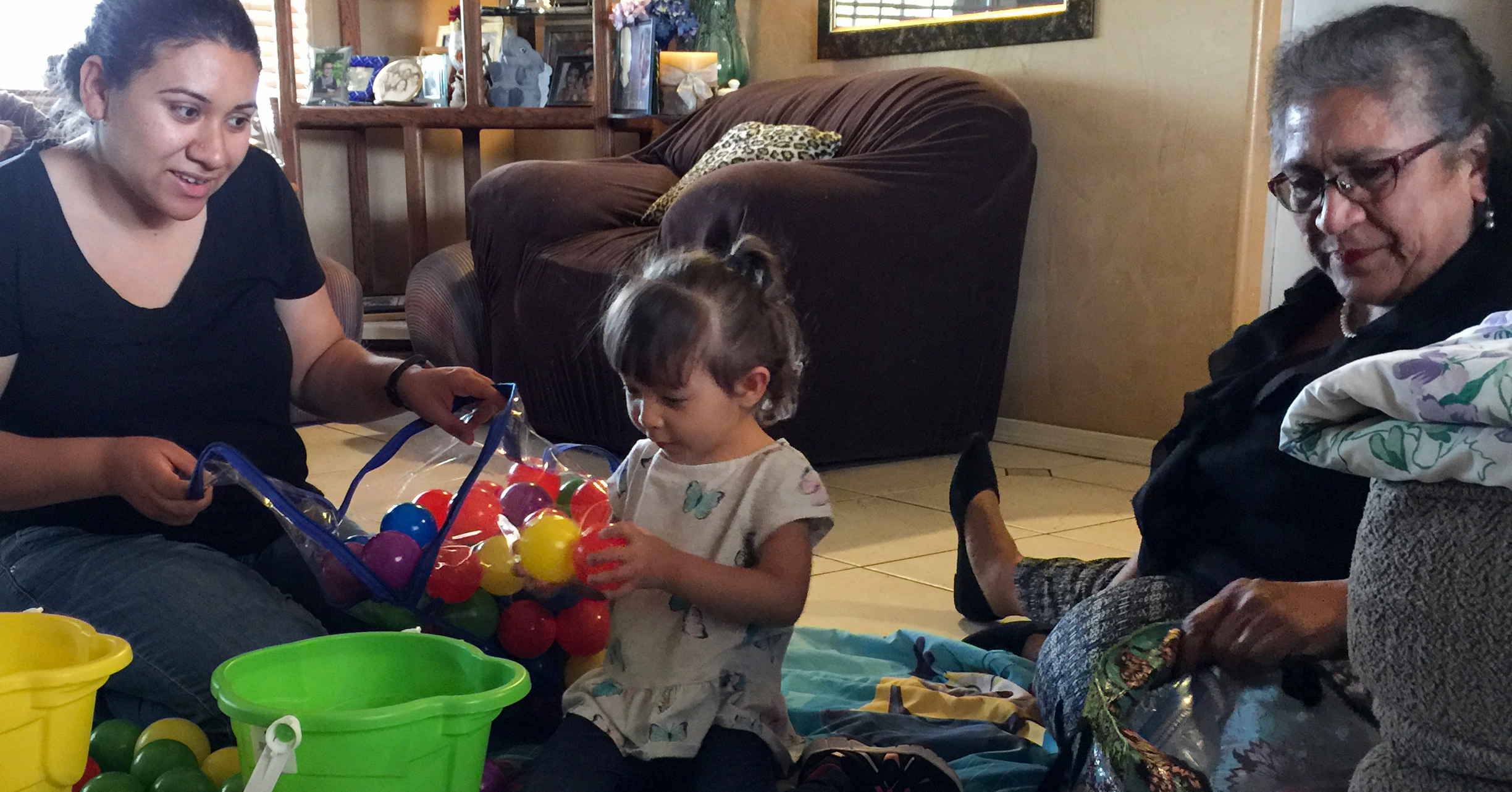 mom working with daughter to sort colored balls.