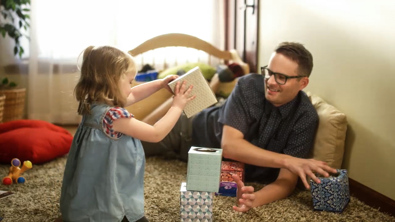 Father and daughter playing with household toys