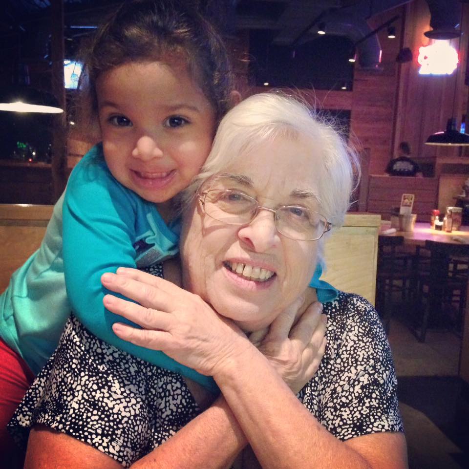 granddaughter hugging grandmother at a restaurant 