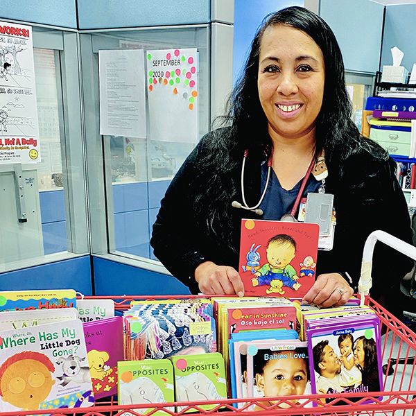 nurse standing next to a basket full of children's books