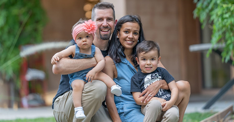 Family on grass, smiling and wearing matching denim