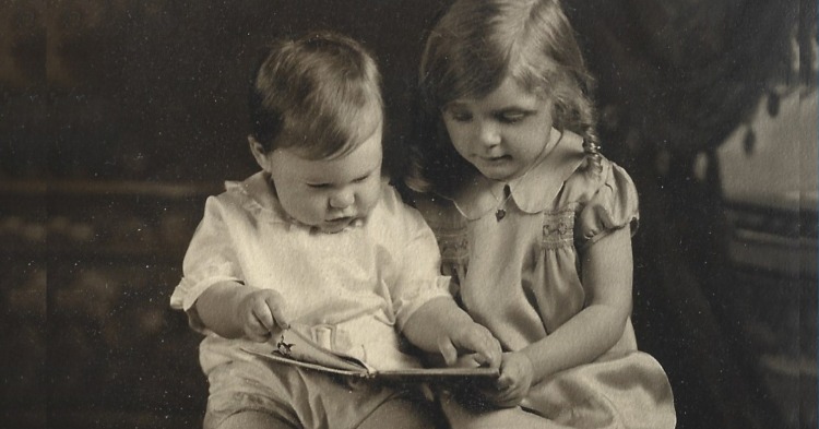 baby photo of Audrey Optiz reading to her baby brother.
