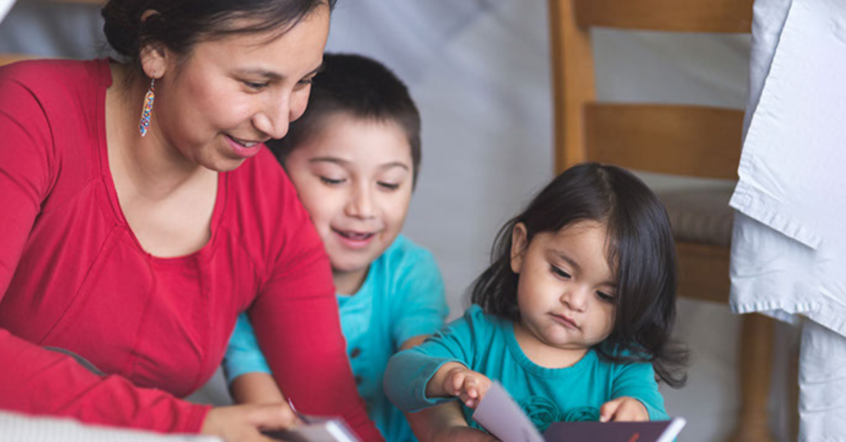 mom reading a book with young boy and girl